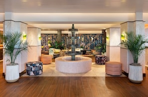 A lobby with a central fountain, seating areas, and decorative wall art. - Ocean Key Resort & Spa (Key West)