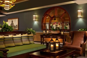 A cozy lounge area with a sofa, armchair, and a wooden coffee table.