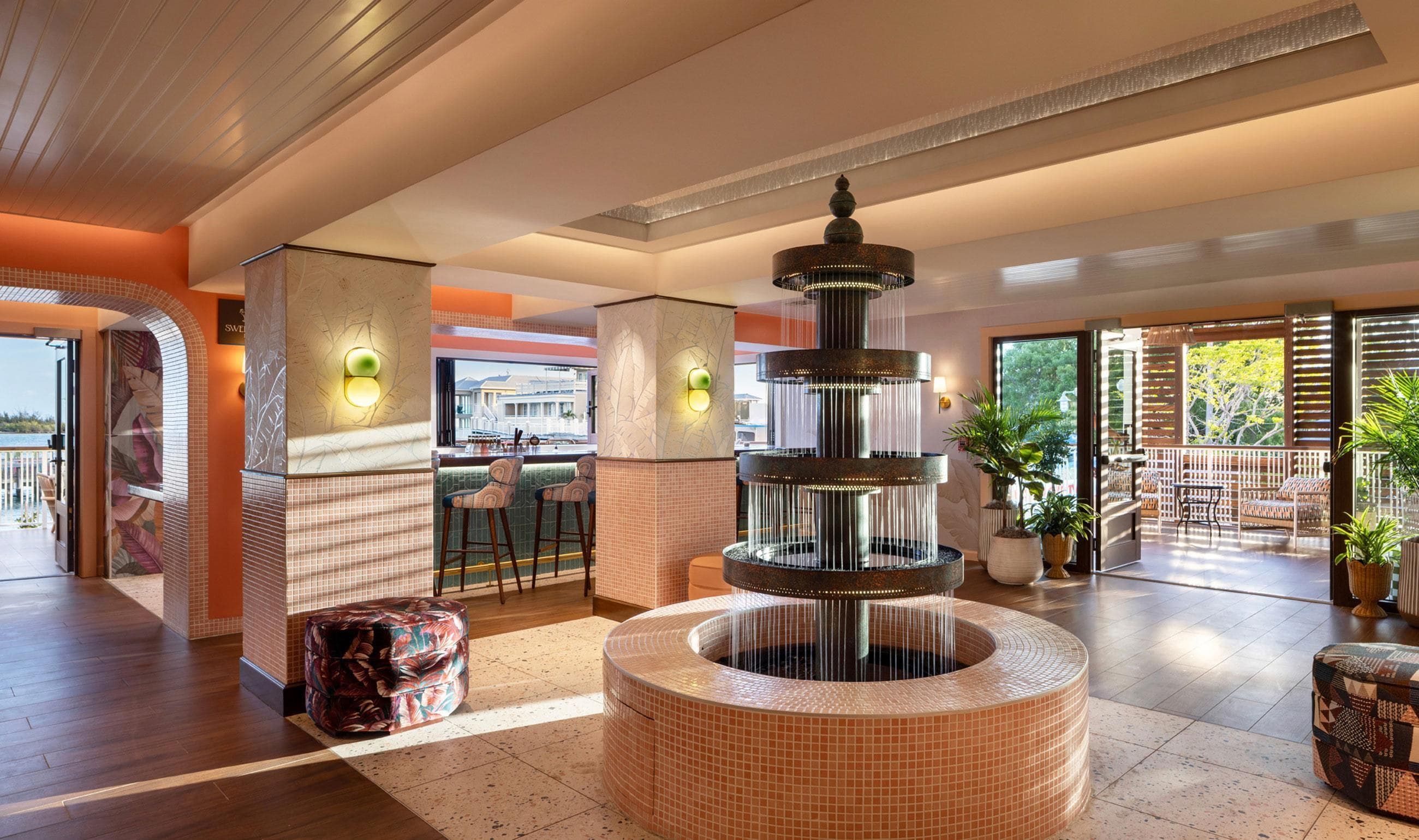 A lobby with a central water feature, seating areas, and a view of the outdoors.