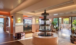A lobby with a central water feature, seating areas, and a view of the outdoors. - Ocean Key Resort & Spa (Key West)