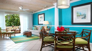 Una habitación luminosa con una pared azul, un ventilador de techo y una mesa de comedor con sillas.