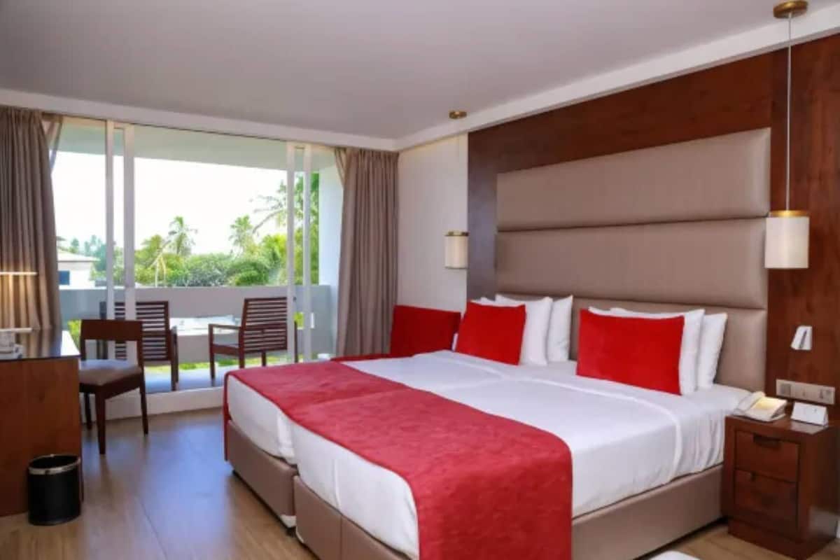 Una habitación de hotel con una cama grande, un escritorio y una silla.