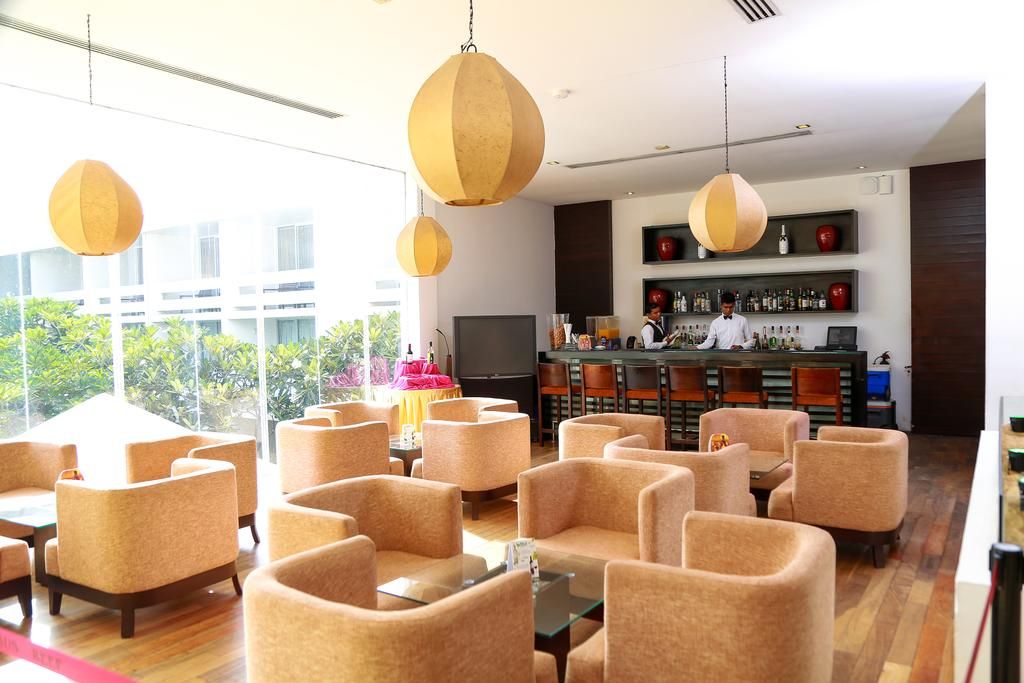 A modern bar area with seating and a bartender.