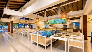 Un restaurante espacioso con techos altos, vigas a la vista y una barra larga.
