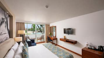 Habitación de hotel con cama, escritorio, televisión y vistas al exterior.
