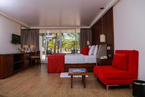 Una habitación de hotel con cama, escritorio, silla, sofá y televisión.