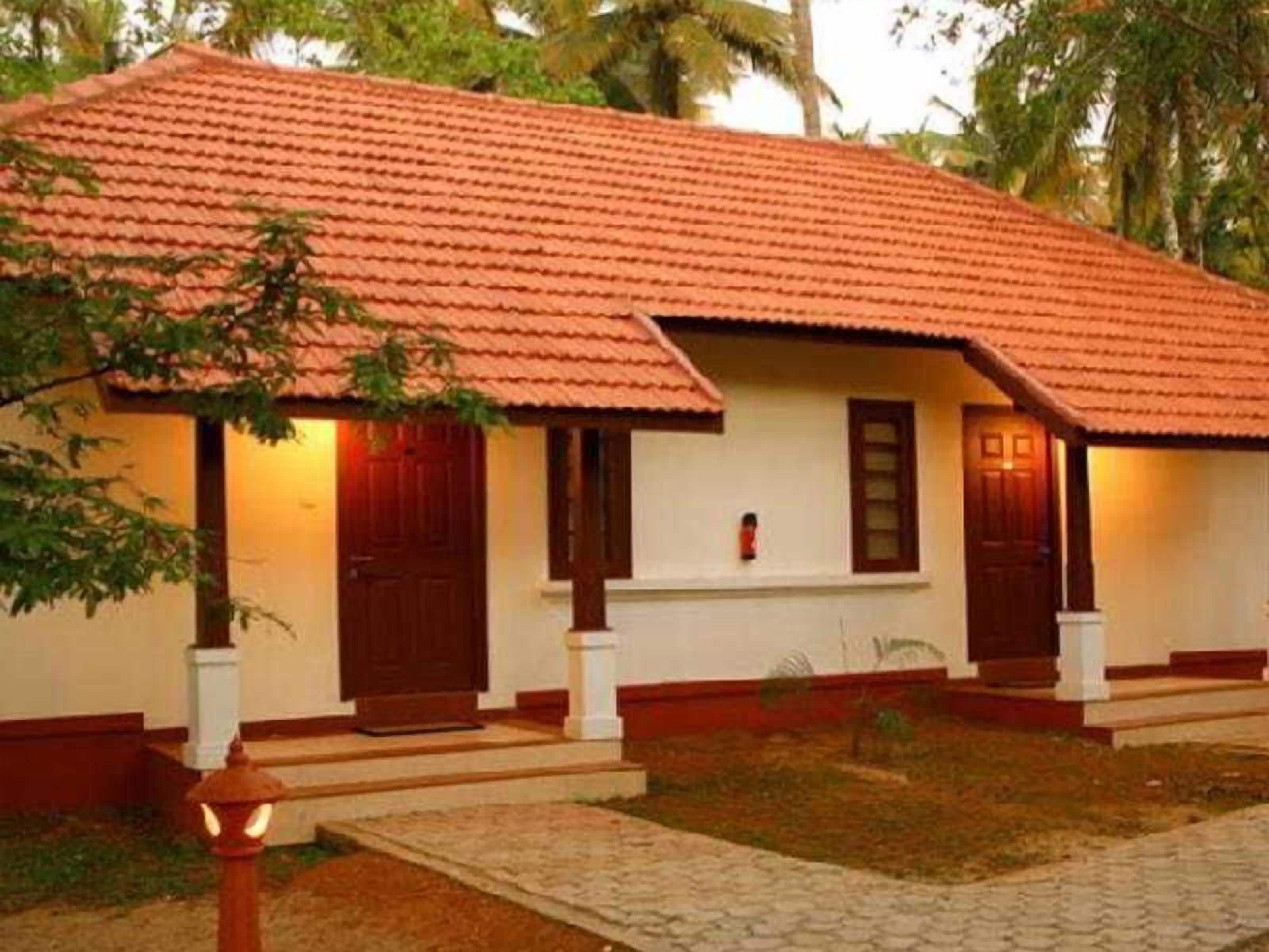 A single-story building with a red-tiled roof, white walls, and wooden doors.