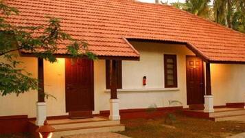 A single-story building with a red-tiled roof, white walls, and wooden doors.