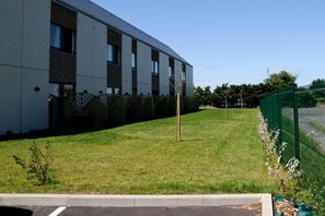 Un bâtiment moderne doté d’un toit plat, de grandes fenêtres et d’une pelouse bien entretenue.