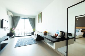 Una habitación de hotel moderna con cocina, una mesa de comedor y un ventanal con cortinas.