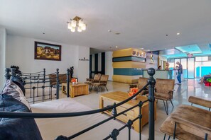 A hotel lobby with a reception desk, seating area, and a painting on the wall. - The Vogue Hotel, Pattaya (Pattaya)