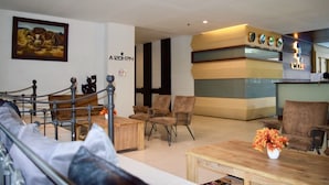 A hotel lobby with a reception desk, seating area, and a painting on the wall. - The Vogue Hotel, Pattaya (Pattaya)