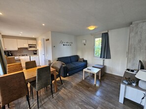 A compact living space with a kitchenette, a dining area, a sofa, and a small table. - RBR 2464 - Beach Resort Kamperland by Interhome (Kamperland)