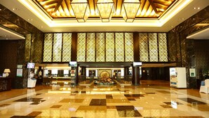 A spacious lobby with a checkered floor, a central fountain, and a reception desk. - Hengshan Park (Beijing)