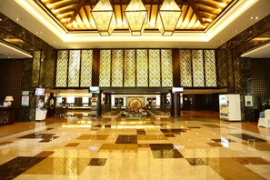 A spacious lobby with a checkered floor, a central fountain, and a reception desk. - Hengshan Park (Beijing)