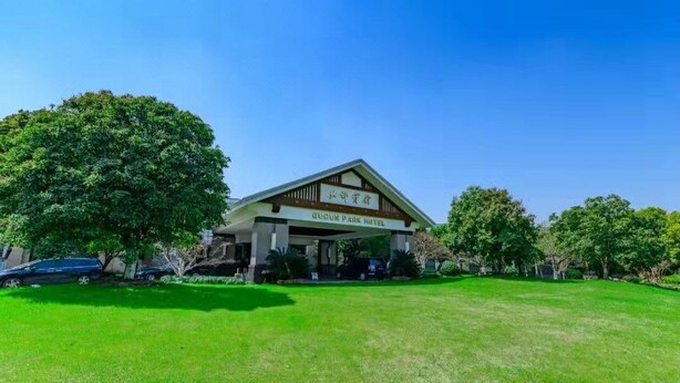 A building with a sign reading 'ZOSUN PARK HOTEL' in front of a well-maintained lawn and trees. - Hengshan Park (Beijing)