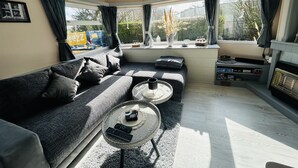 A living room with a sofa, a coffee table, and a fireplace. - RBR 1747 - Beach Resort Kamperland by Interhome (Kamperland)