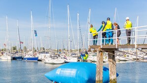 A marina with boats docked, a large blue inflatable structure, and people on a dock. - RBR 1747 - Beach Resort Kamperland by Interhome (Kamperland)