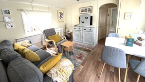 Een woonkamer met een bank, een stoel, een tafel en een kast.
