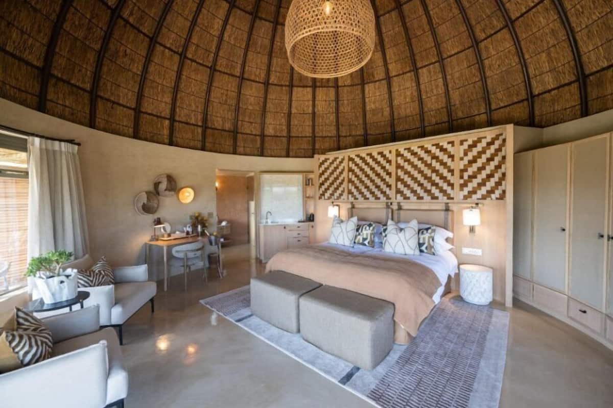 Un dormitorio amplio con una cama grande, un escritorio y una zona de estar.