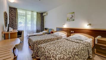 A hotel room with two beds, a desk, a chair, a telephone, and a painting on the wall.