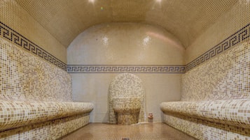 A tiled bathroom with a curved ceiling and two sinks.