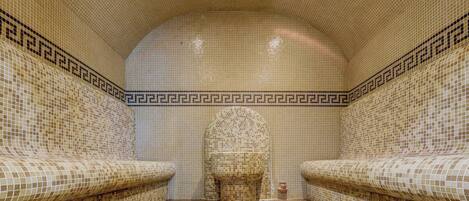 A tiled bathroom with a curved ceiling and two sinks.