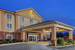 Un hotel Comfort Inn con entrada cubierta, un letrero que indica una altura libre de 36 metros y fachada de ladrillo.