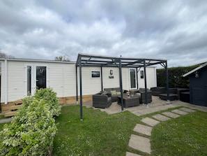 A mobile home with a patio area featuring outdoor furniture and a pergola. - RBR 264 - Beach Resort Kamperland by Interhome (Kamperland)