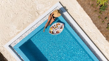 A pool with a tiled edge and a circular tray of food items.