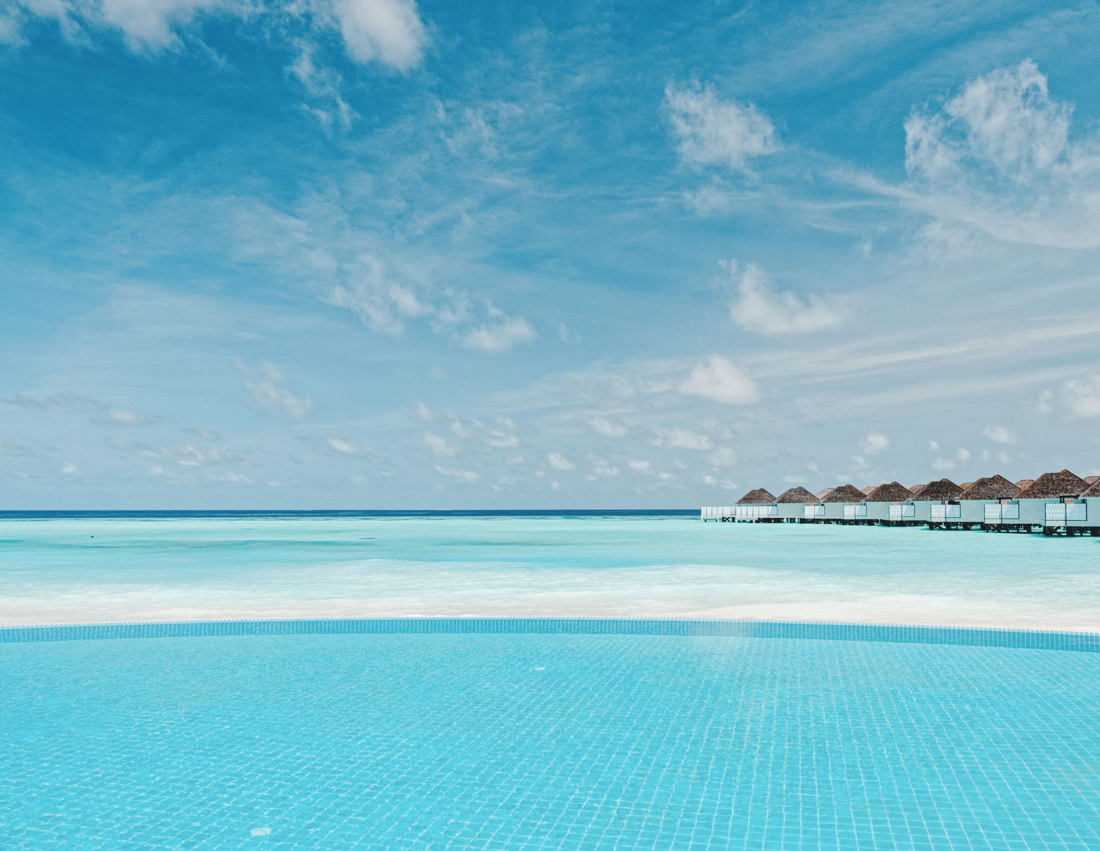 A clear blue pool with overwater bungalows.