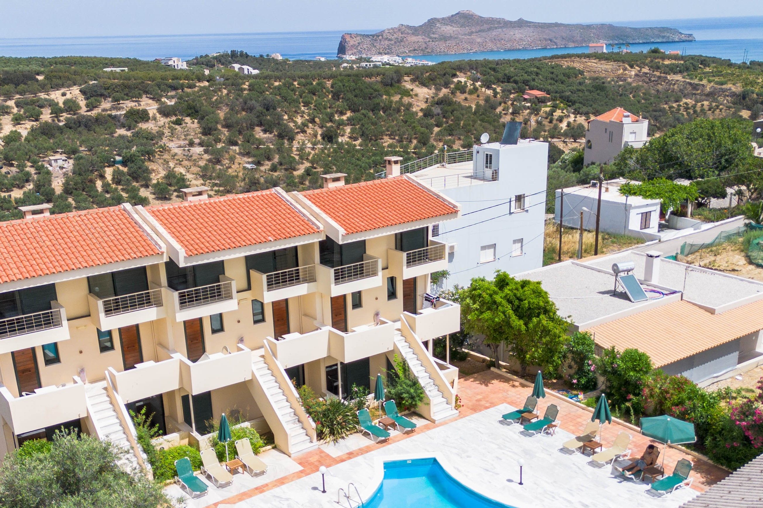 Un hôtel à plusieurs étages doté d’une piscine, d’un espace extérieur aménagé et offrant une vue sur la mer.