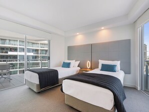 A modern hotel room with two beds, a large window, and a balcony with a view of the city. - Mantra Sirocco Mooloolaba (Sunshine Coast)