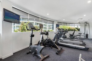 Moderni kuntokeskus, jossa on juoksumattoja, kuntopyörä ja crosstrainer.