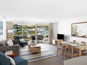 A modern hotel room with a balcony, a dining area, and a seating area. - Mantra Zanzibar Mooloolaba (Sunshine Coast)