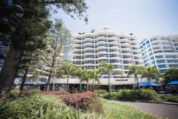 A multi-story hotel with balconies, a restaurant, and lush greenery. - Mantra Zanzibar Mooloolaba (Sunshine Coast)