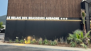 A hotel building with a modern design, featuring a prominent sign that reads "HOTEL LE RELAIS DES BRASSEURS." - Hotel le Relais des Brasseurs (Aubagne)