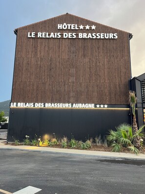 Ein Hotelgebäude im modernen Stil, mit einem gut sichtbaren Schild mit der Aufschrift "HOTEL LE RELAIS DES BRASSEURS".