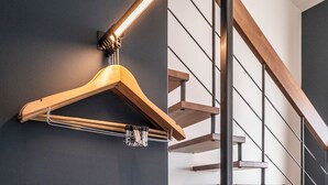 A modern interior with a wooden staircase, a hanging light fixture, and a beige sofa. - Hotel le Relais des Brasseurs (Aubagne)