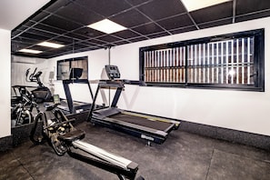 A gym with treadmills, stationary bikes, and a rowing machine. - Hotel le Relais des Brasseurs (Aubagne)