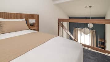 Quarto com cama grande, cabeceira de madeira, mesa de cabeceira com rádio e vista para uma escadaria que leva a uma varanda.