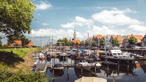 A marina with boats docked, a church with a tower, and traditional buildings with red roofs. - RBR 722 - Beach Resort Kamperland by Interhome (Kamperland)