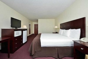 A hotel room with a bed, a television, a microwave, a desk, and a telephone. - Best Western Executive Inn (Carrollton)