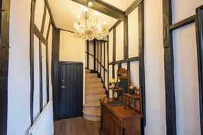 A staircase with a chandelier, a wooden bench, and a mirror. - The Merchant House, Ipswich (Ipswich)