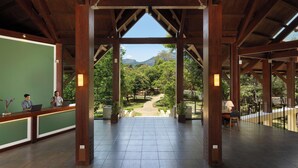Recepção com vista para um jardim ajardinado e montanhas.
