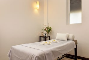 A single bed with a white bedspread, a bedside table with a plant, a wall-mounted light, and a window. - The Paradise Dambulla (Kandalama)