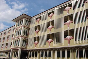 Um hotel com vários andares e um design arquitetônico marcante, com linhas verticais e uma torre central.