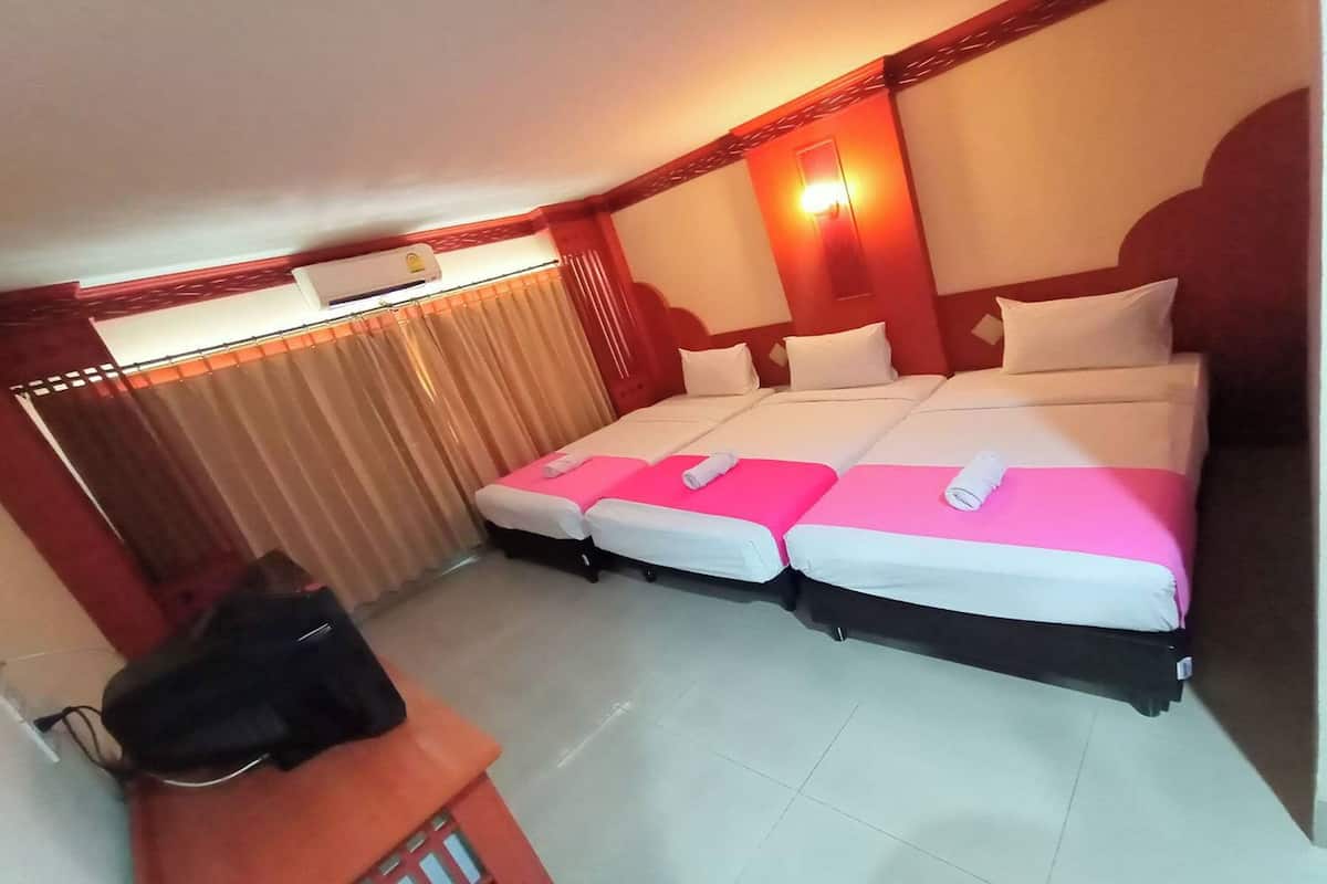 A hotel room with a large bed, a desk, and a chair.