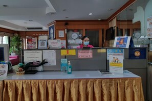A reception desk with informational posters, a contact sign, and a QR code. - Poonsook Phitsanulok Hotel SHA Plus+ by Zuzu (Phitsanulok)