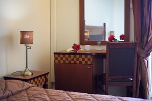 A hotel room with a bed, a bedside table with a lamp, a dresser, a mirror, and a chair. - Pontikonissi Adults Only (Corfu)